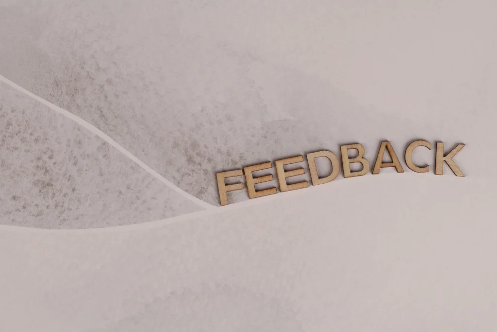 Wooden letters spelling FEEDBACK on textured paper background