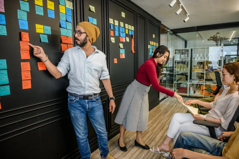 Team members collaborating in a modern office with sticky notes for sprint planning