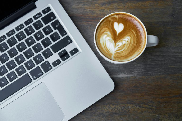 Coffee and laptop representing morning marketing routine