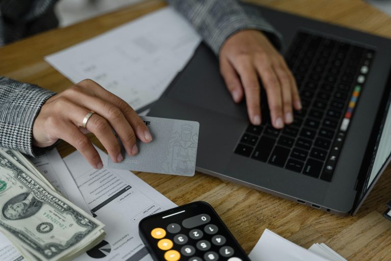 Person using credit card and laptop to manage subscription billing and recurring payments